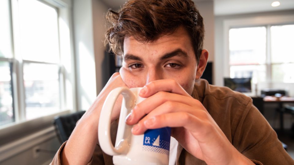 Hombre con expresión de cansancio tomando café en la mañana