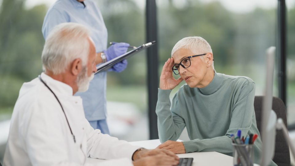 Médico en consulta con una paciente adulta mayor evaluando su salud cardiovascular